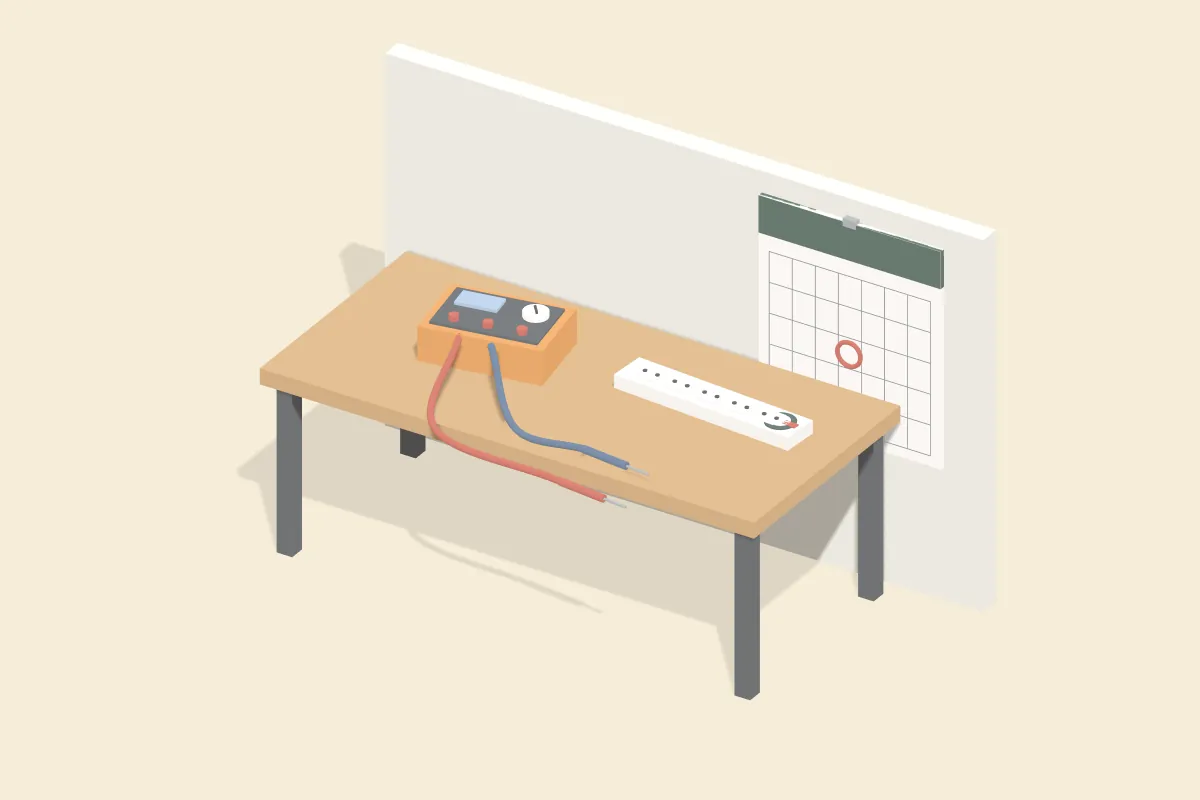 Prüfgerät mit Messleitungen und Mehrfachsteckdose mit Prüfplakette auf einem Tisch, an der Wand ein Kalender mit eingekreistem Datum