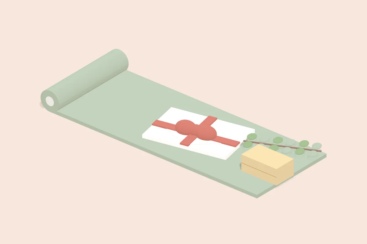 Geschenkumschlag mit Schleife auf einer Yogamatte, daneben Korkklotz und Eukalyptuszweig